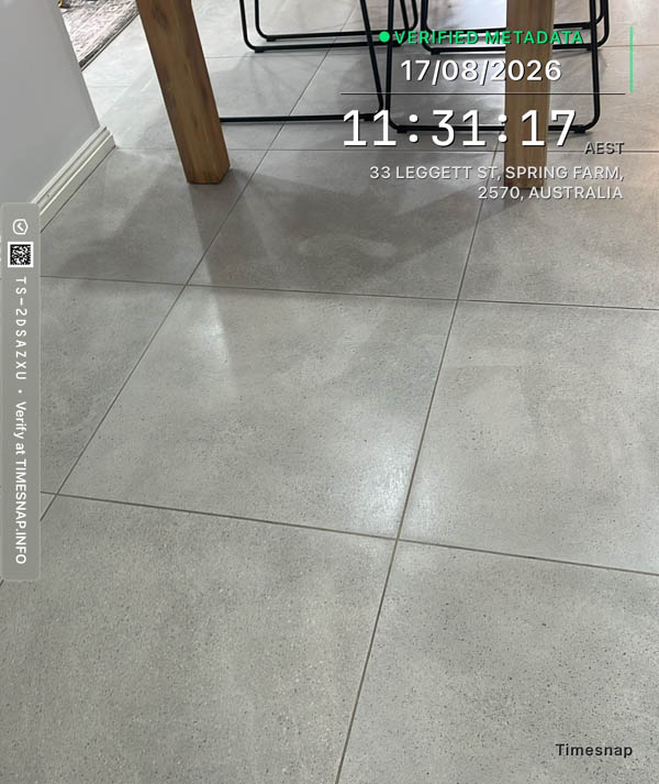 Cleaner wiping down a kitchen bench during a regular clean